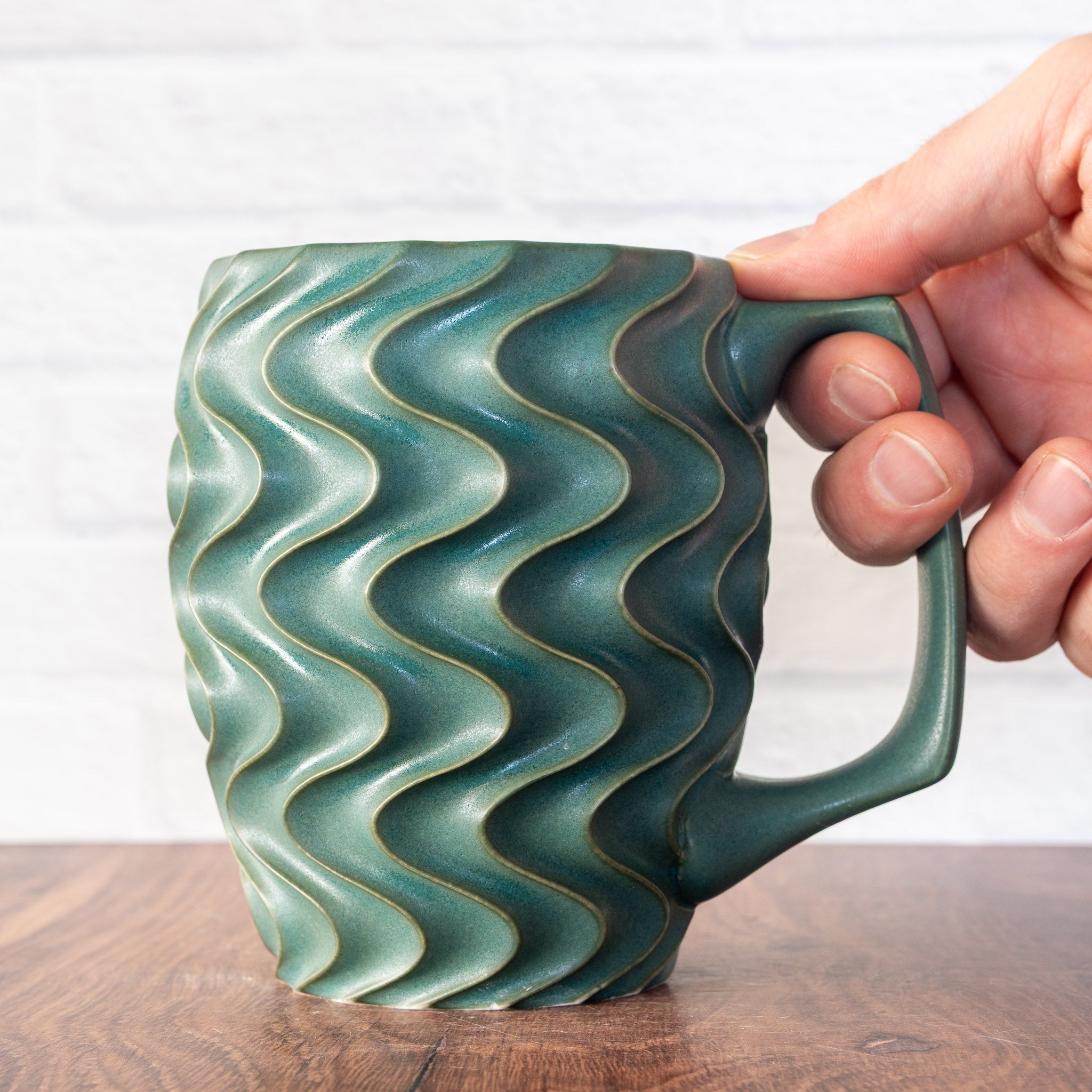 Hammerly Ceramics handmade slip-cast mug in smooth, matte jade green, deep wavy textured porcelain with angular handle