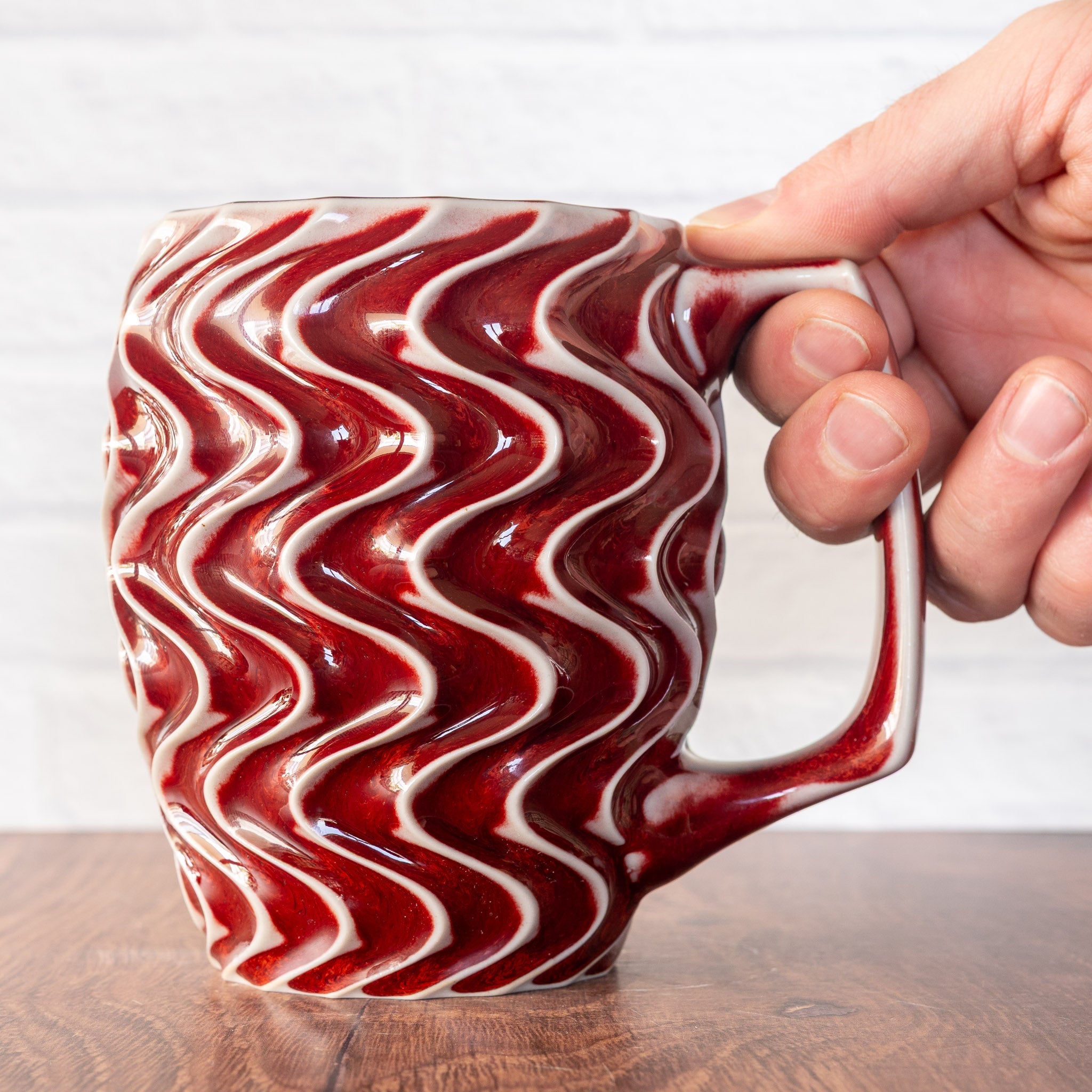 Hammerly Ceramics handmade slip-cast mug in glossy vivid red glaze, deep wavy textured porcelain with angular handle