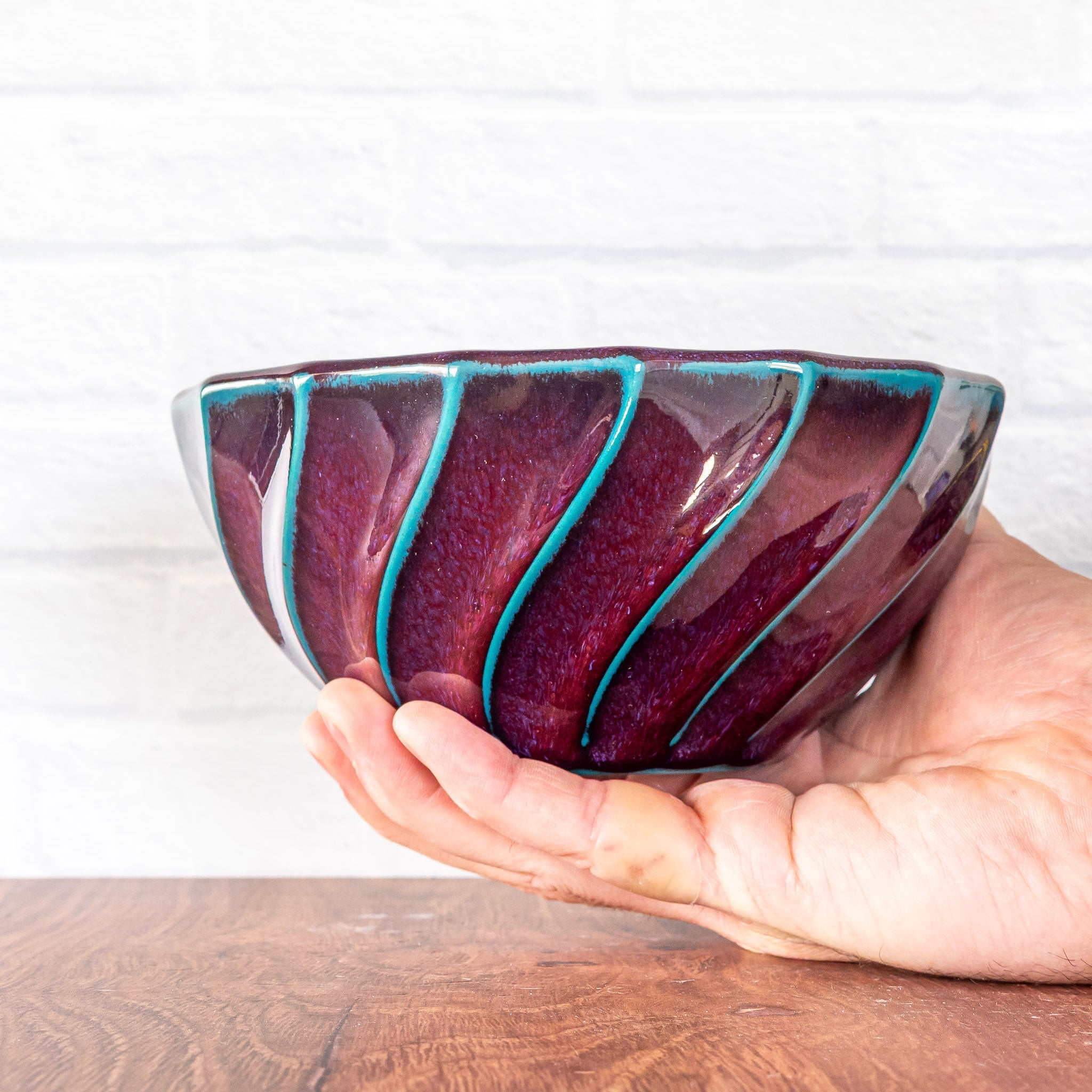 Hammerly Ceramics handmade slip-cast bowl in glossy deep crimson and teal, geometric twist texture