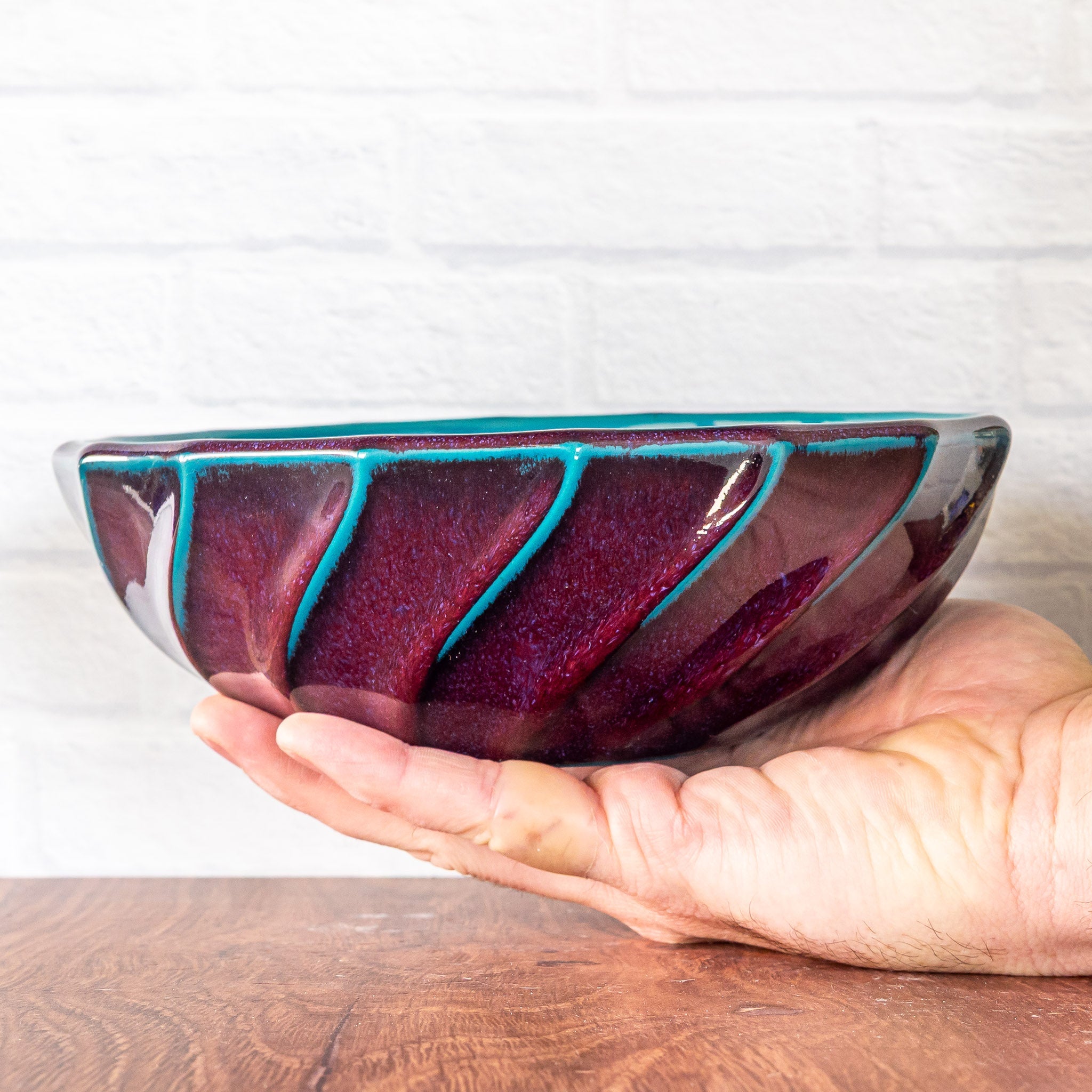 Hammerly Ceramics handmade slip-cast bowl in glossy deep crimson and teal, geometric twist texture