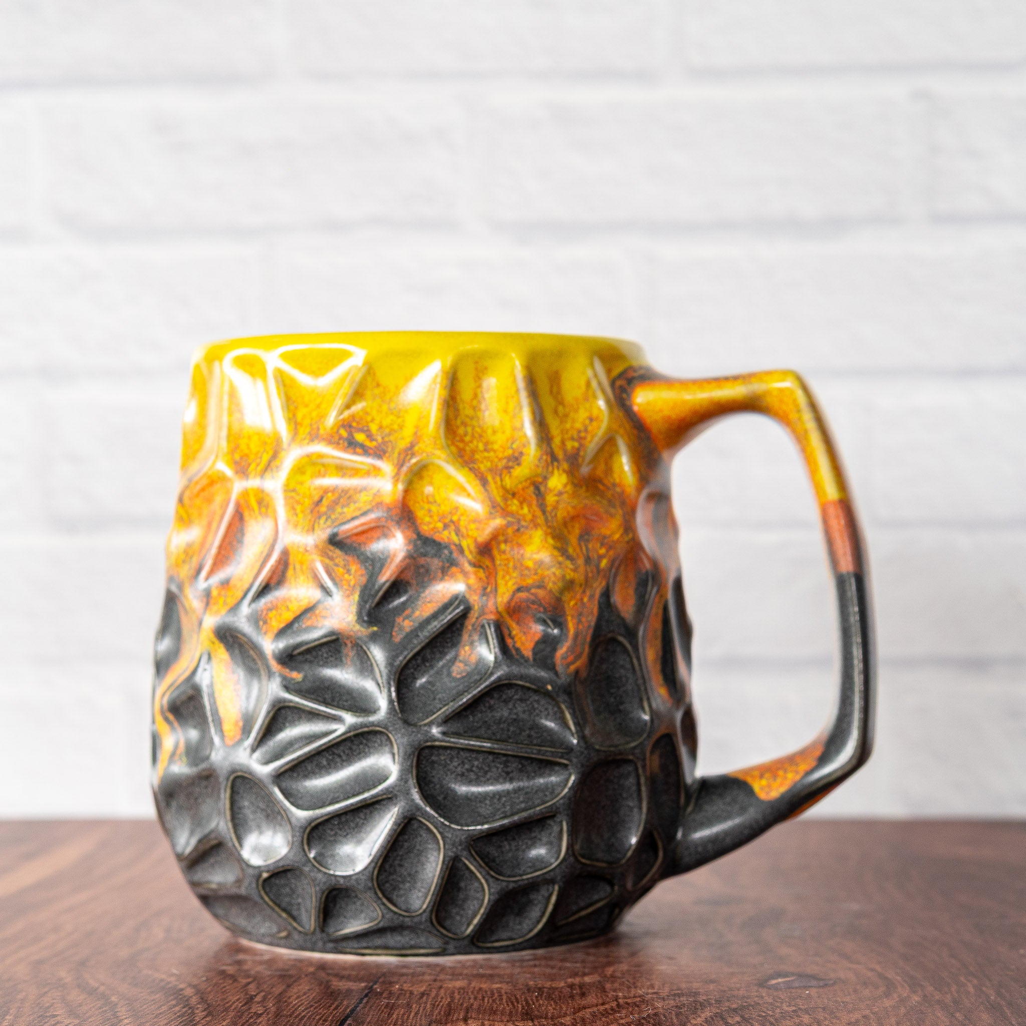 Hammerly Ceramics handmade slip-cast mug in cascading orange and yellow over matte black, geometric organic cell-like textured porcelain