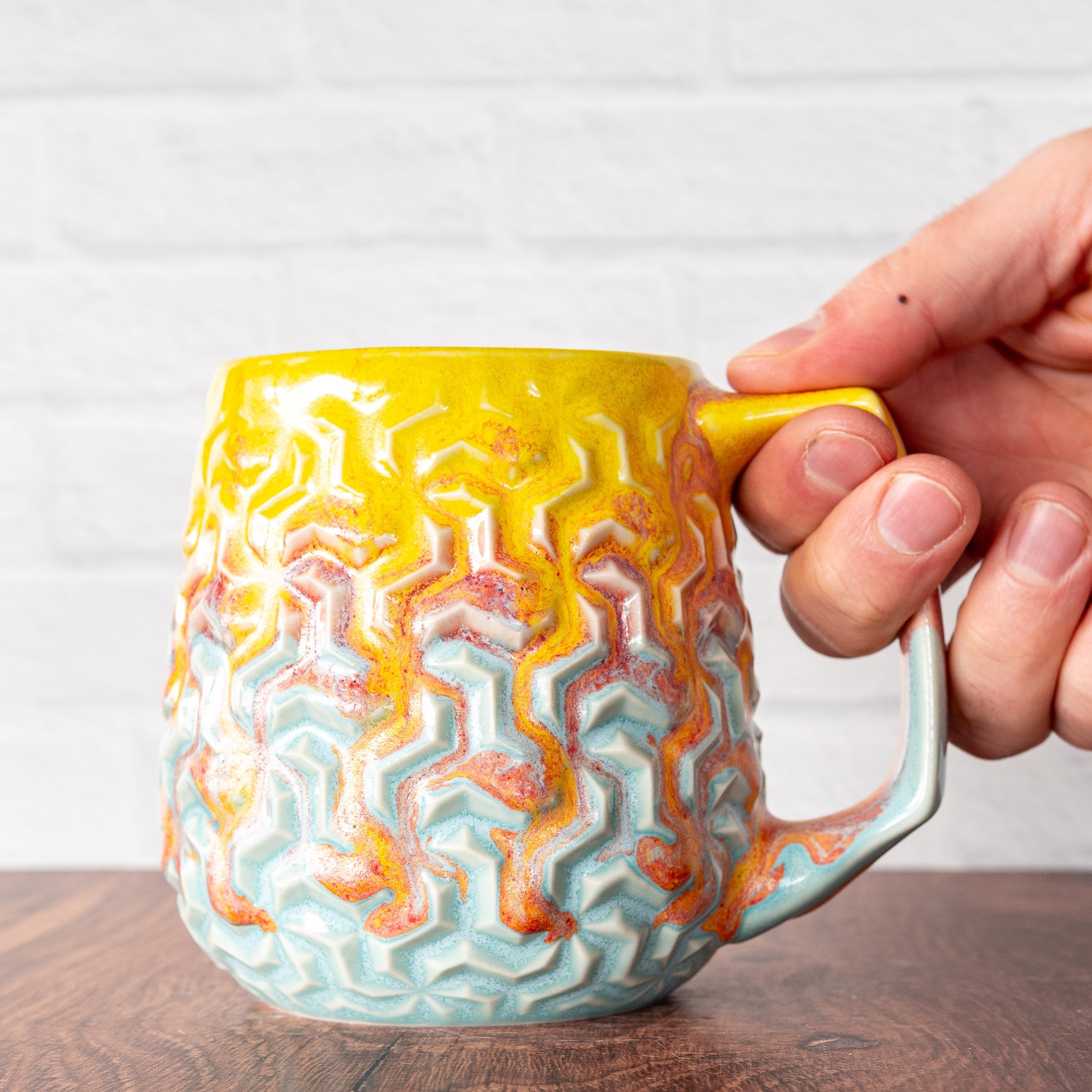 Hammerly Ceramics handmade decorative statue in yellow and sky blue with flowing orange blush, interlocking geometric weave textured porcelain