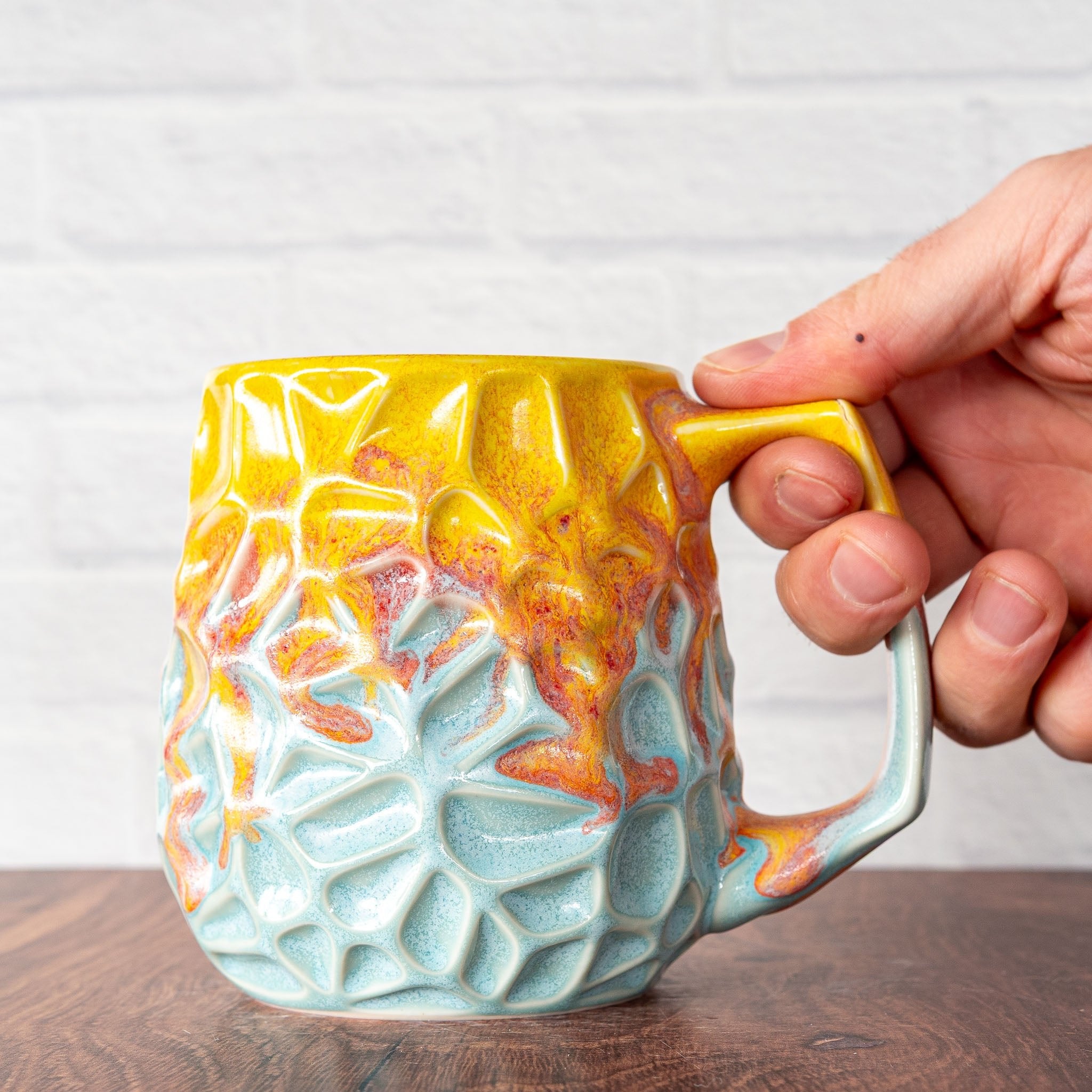 Hammerly Ceramics handmade slip-cast mug in yellow and sky blue with flowing orange blush, geometric organic cell-like textured porcelain