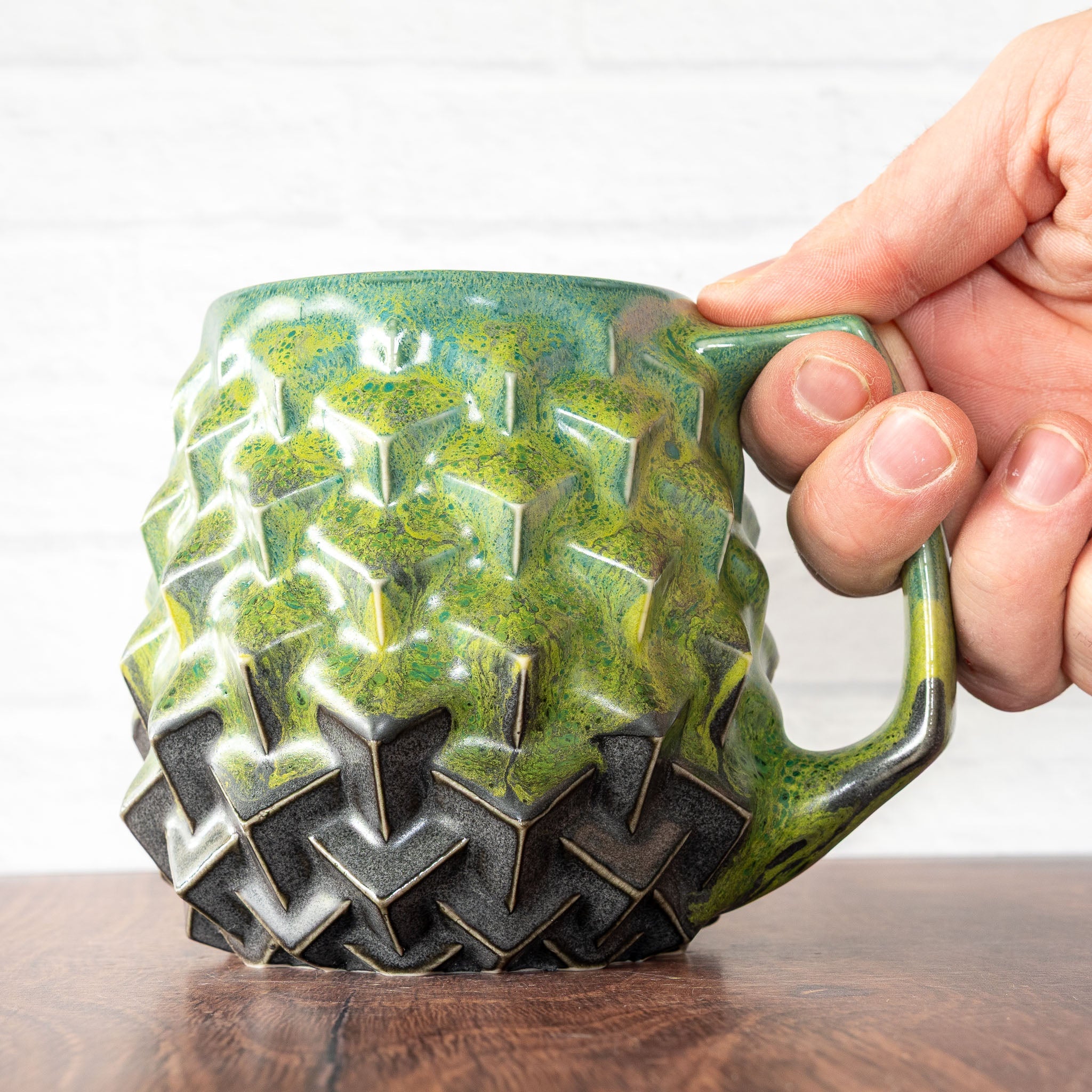 Hammerly Ceramics handmade slip-cast mug in light green and teal flowing over charcol black, geometric cubes textured porcelain