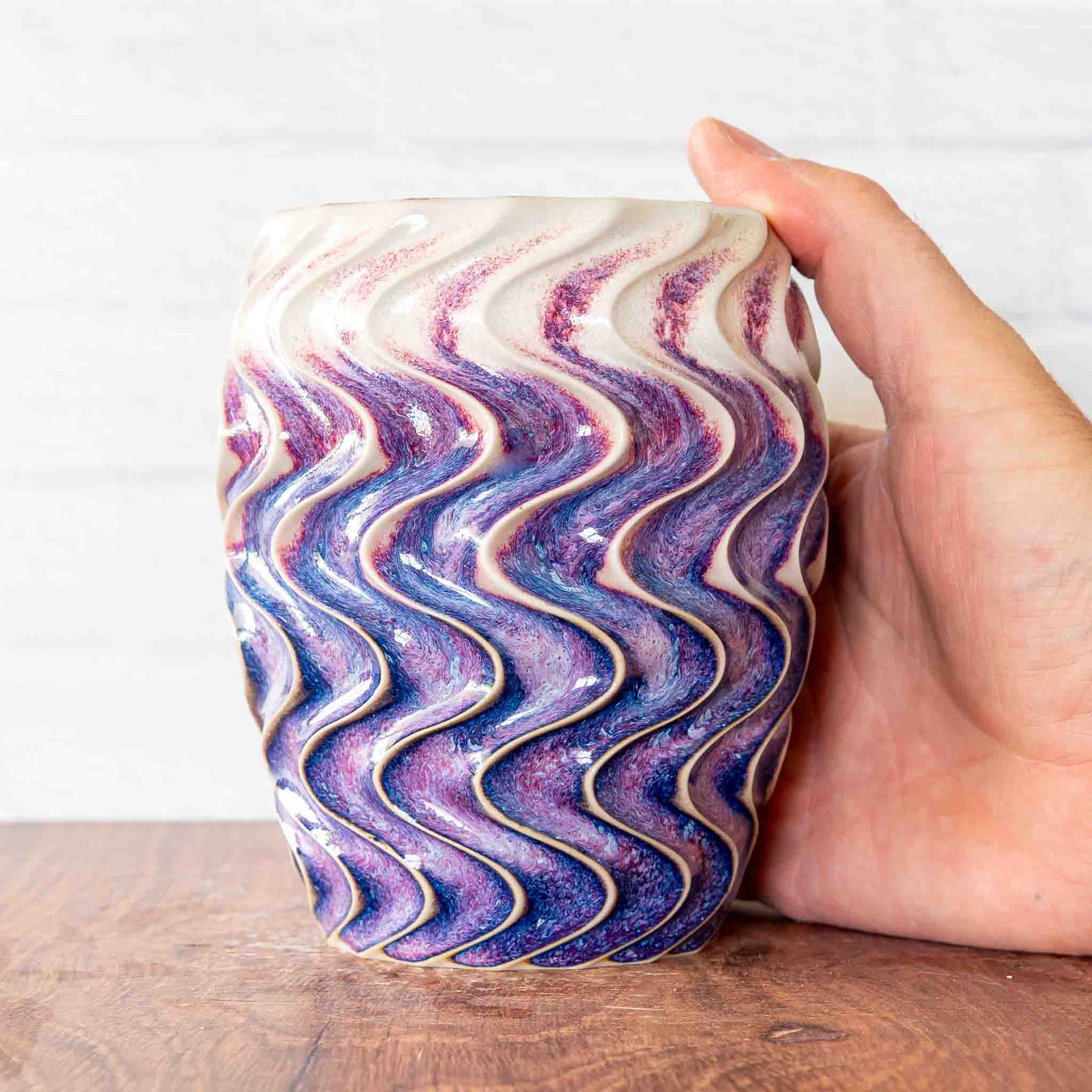 Hammerly Ceramics handmade slip-cast cup in white and deep navy glaze with purple drip transition, deep wavy textured porcelain