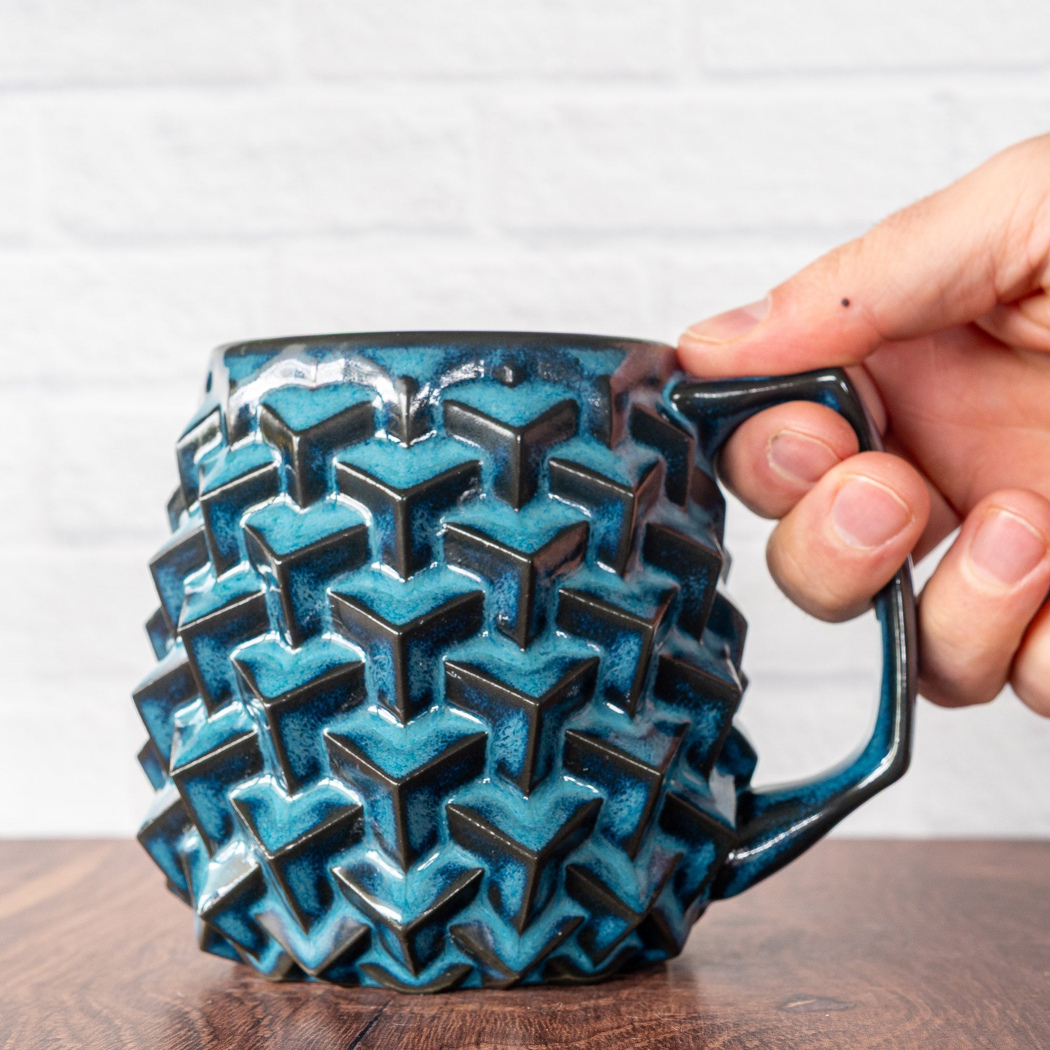Hammerly Ceramics handmade slip-cast mug in ocean blue glaze with dark charcoal edges, geometric cubes textured porcelain