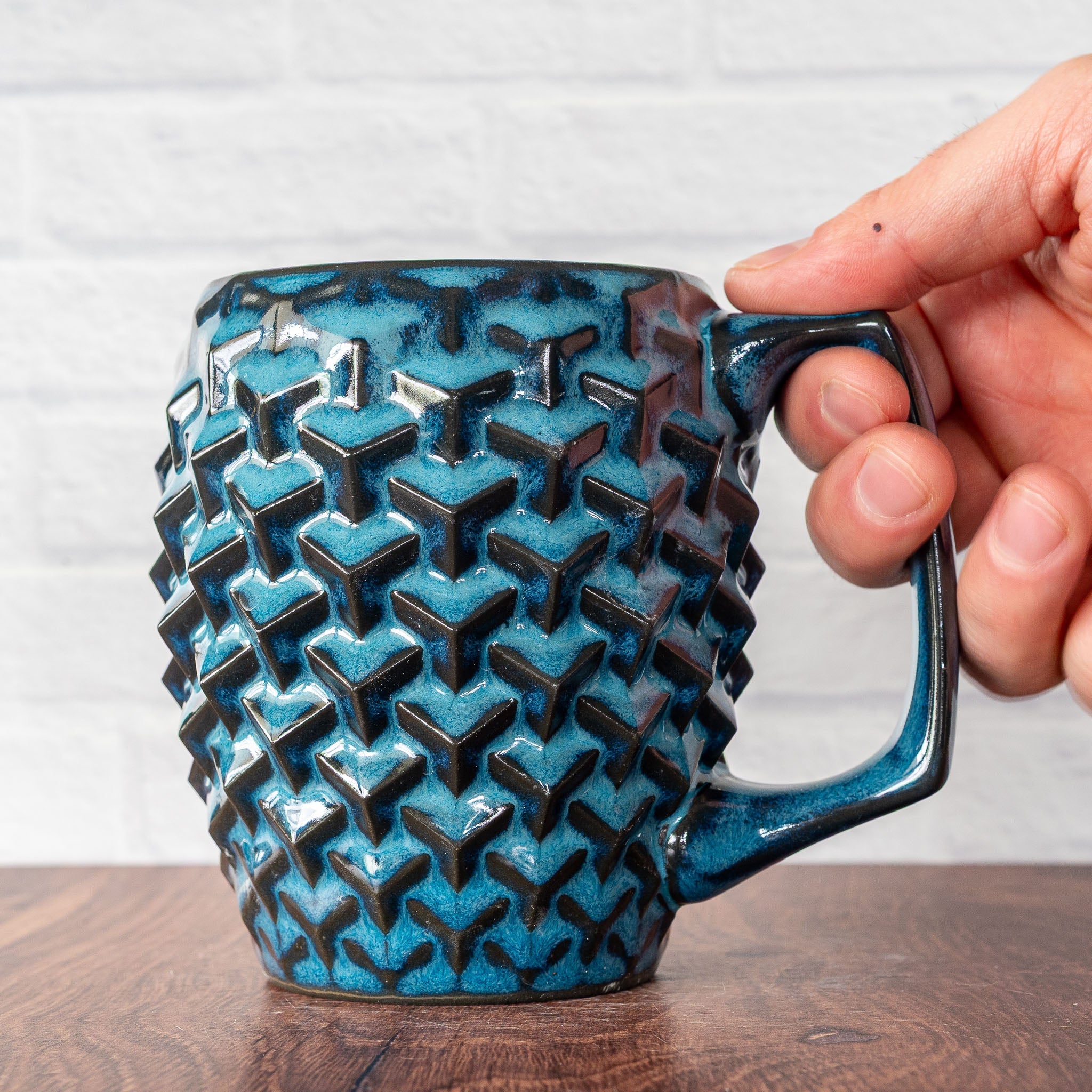 Hammerly Ceramics handmade slip-cast mug in ocean blue glaze with dark charcoal edges, geometric cubes textured porcelain
