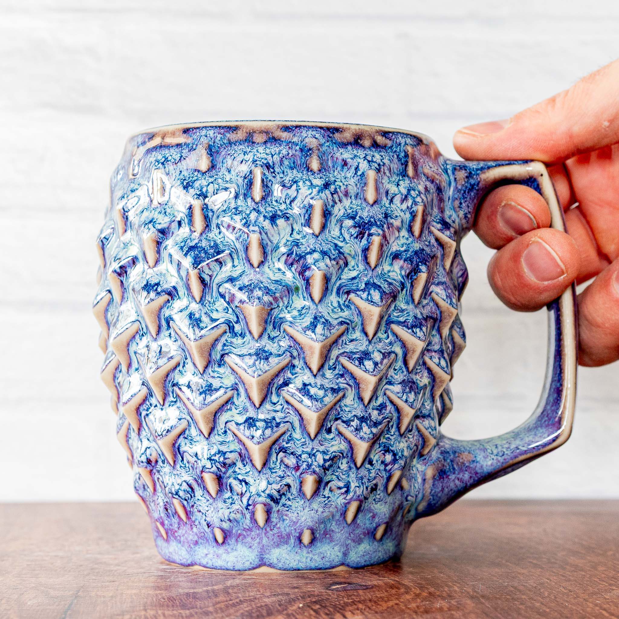 Hammerly Ceramics handmade slip-cast mug in swirls of various shades of blue, geometric cubes textured porcelain