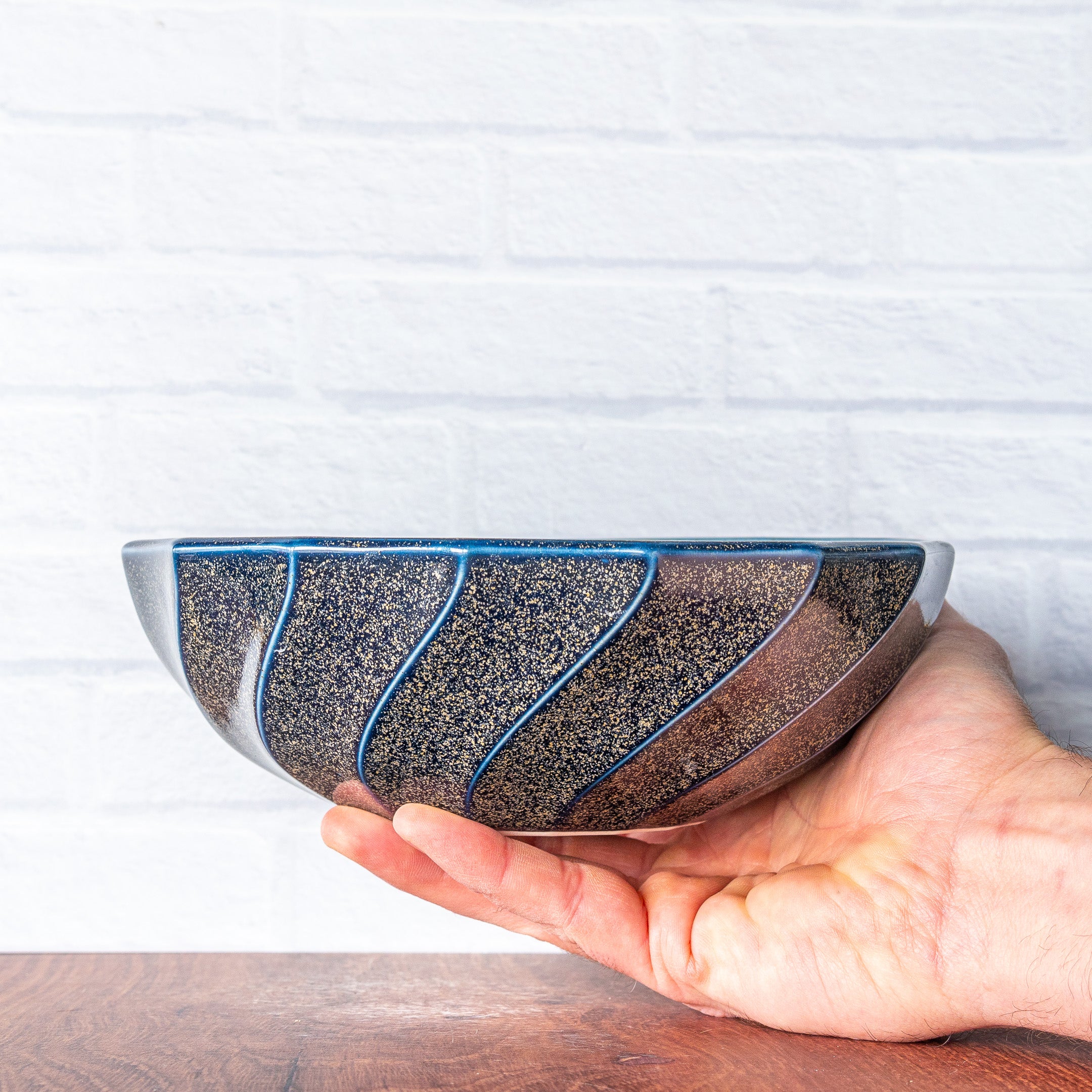 Hammerly Ceramics handmade slip-cast bowl in glossy deep navy glaze with gold speckles, spiral ribbing and a wide form