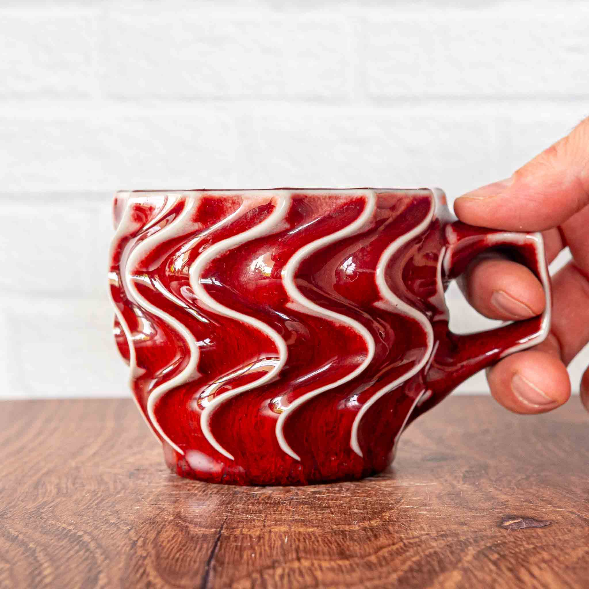 Hammerly Ceramics handmade slip-cast mug in glossy vivid red glaze, deep wavy textured porcelain with angular handle