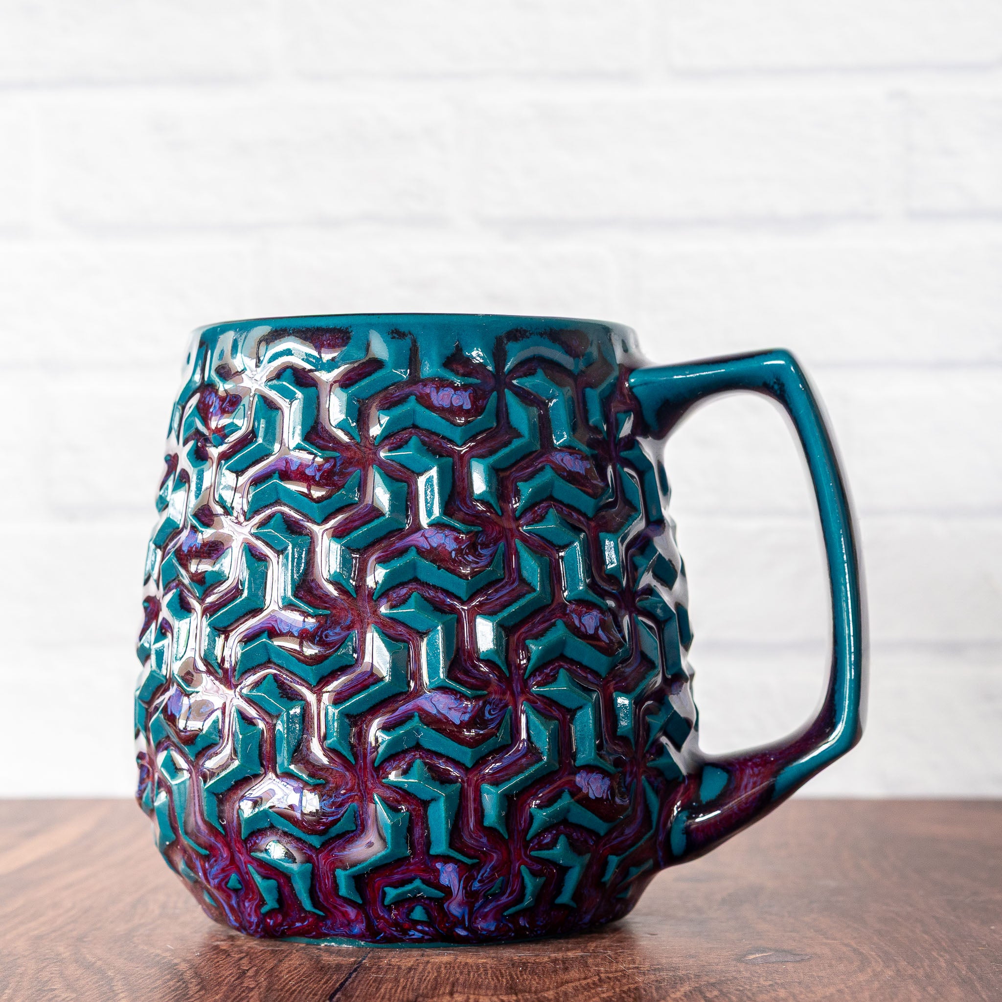 Hammerly Ceramics handmade slip-cast mug in glossy deep crimson and teal, interlocking geometric weave textured porcelain