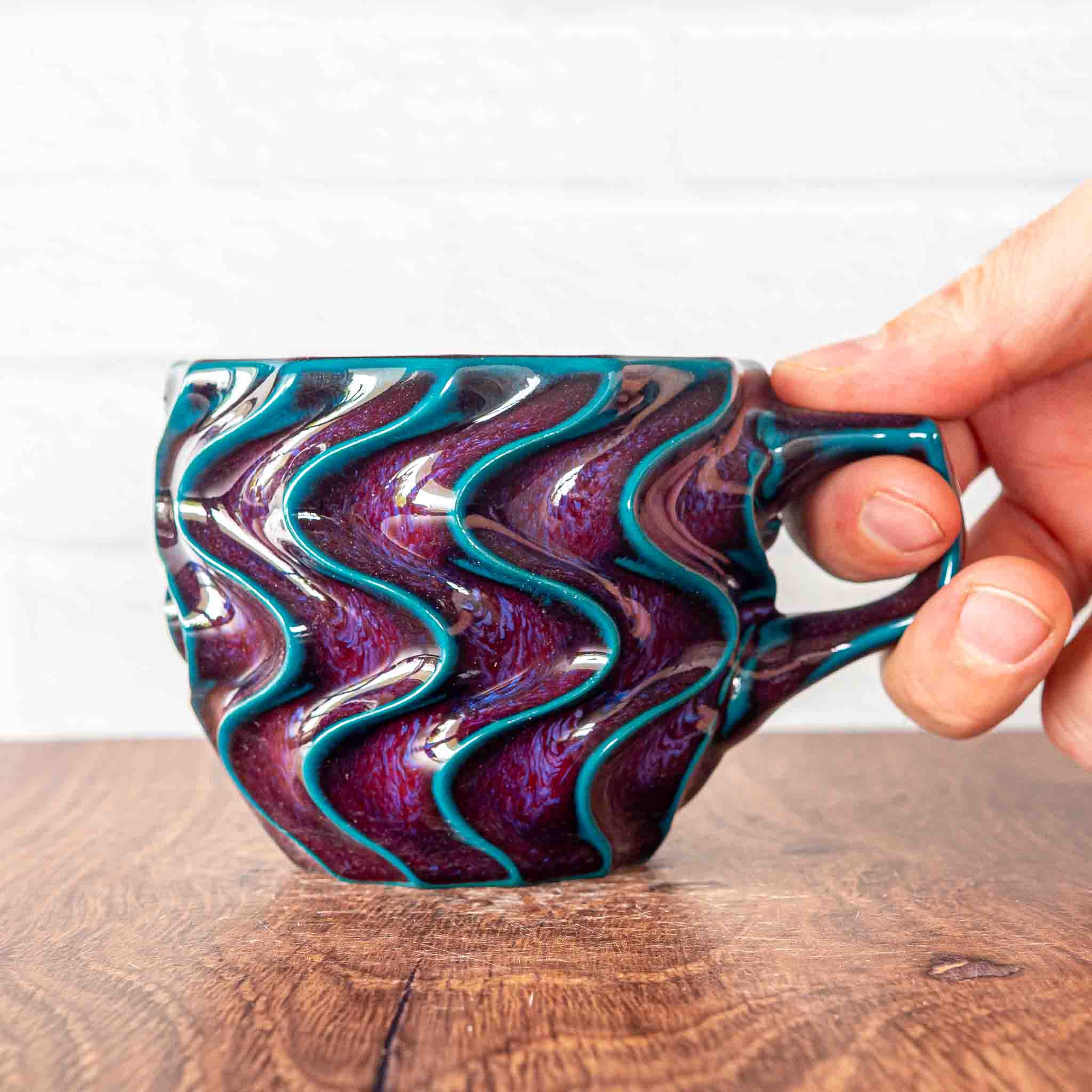 Hammerly Ceramics handmade slip-cast mug in glossy deep crimson and teal, deep wavy textured porcelain with angular handle