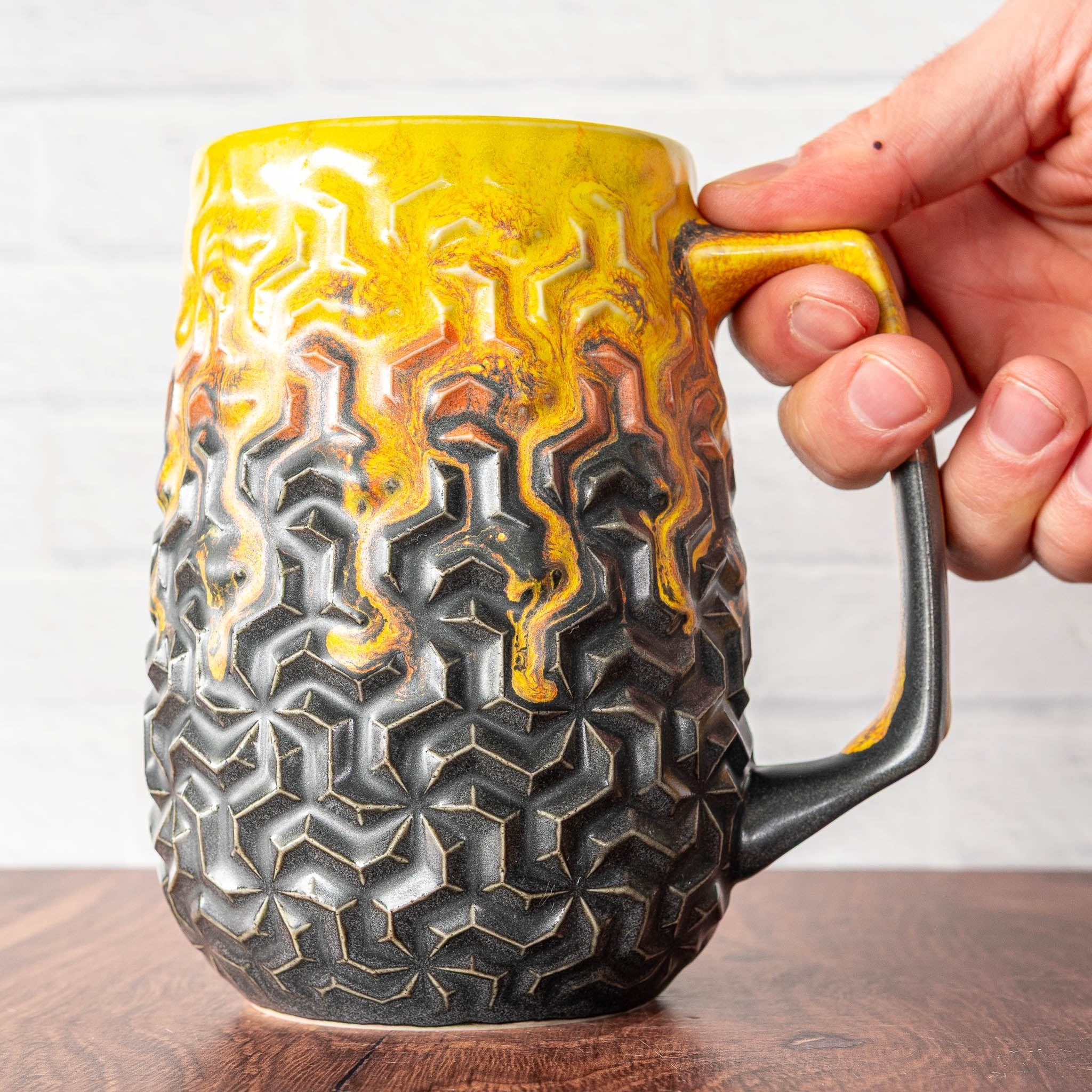 Hammerly Ceramics handmade decorative statue in cascading orange and yellow over matte black , interlocking geometric weave textured porcelain