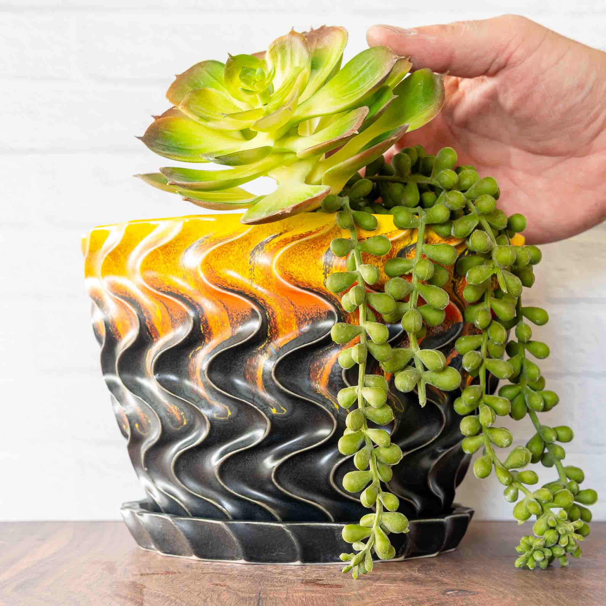 Hammerly Ceramics handmade slip-cast planter in cascading orange and yellow over matte black, deep wavy textured porcelain with drip tray