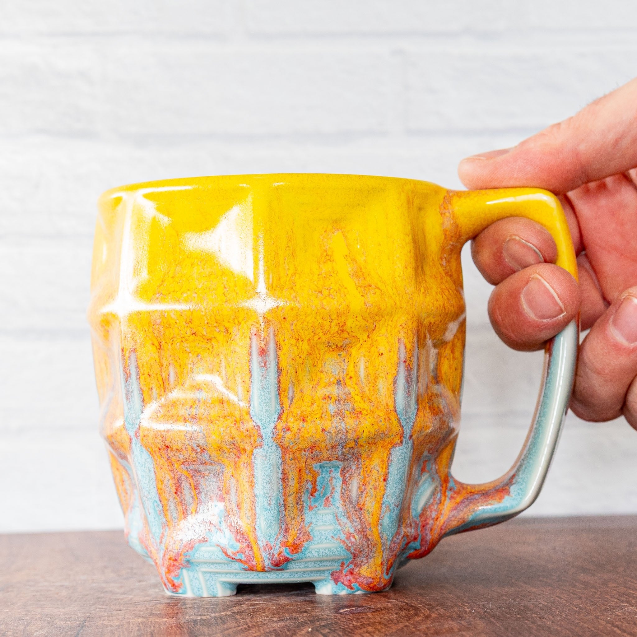 Hammerly Ceramics handmade slip-cast mug in yellow and sky blue with flowing orange blush, barrel-shaped with concentric recessed squares 