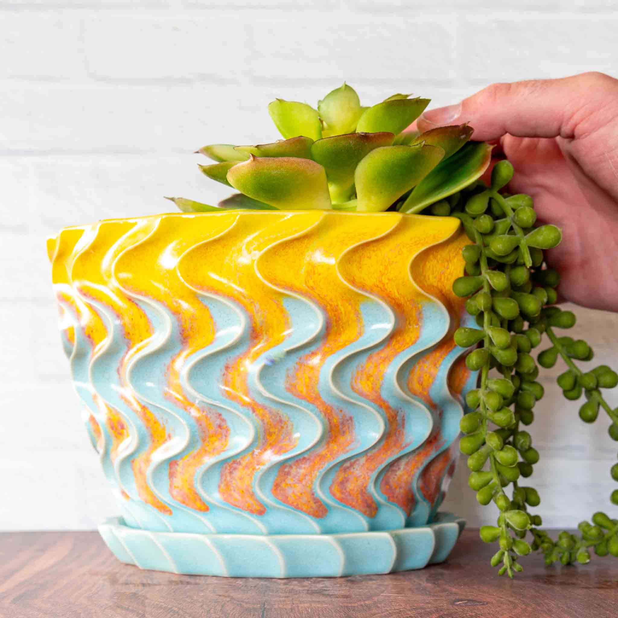 Hammerly Ceramics handmade slip-cast planter in yellow and sky blue with flowing orange blush, deep wavy textured porcelain with drip tray