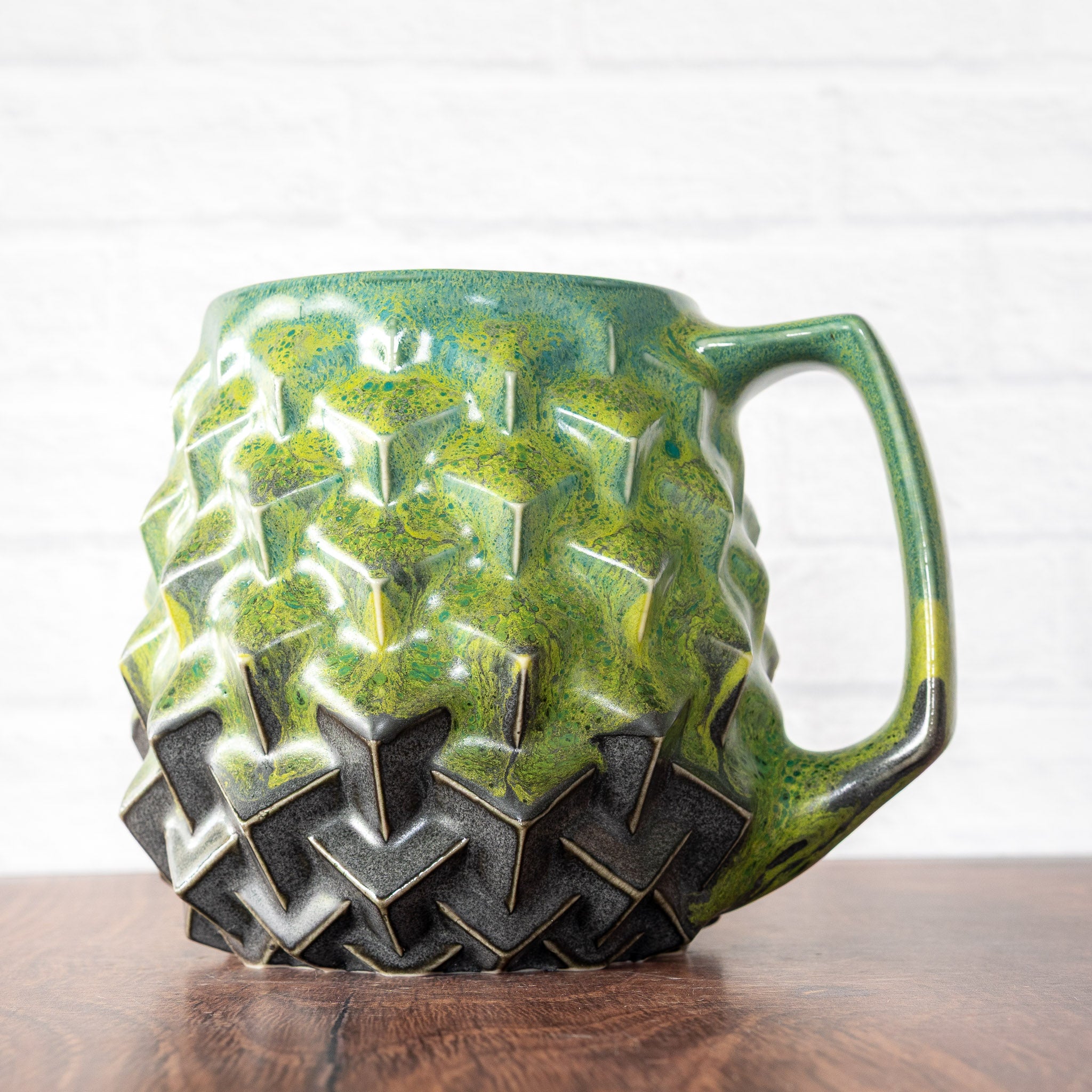 Hammerly Ceramics handmade slip-cast mug in light green and teal flowing over charcol black, geometric cubes textured porcelain