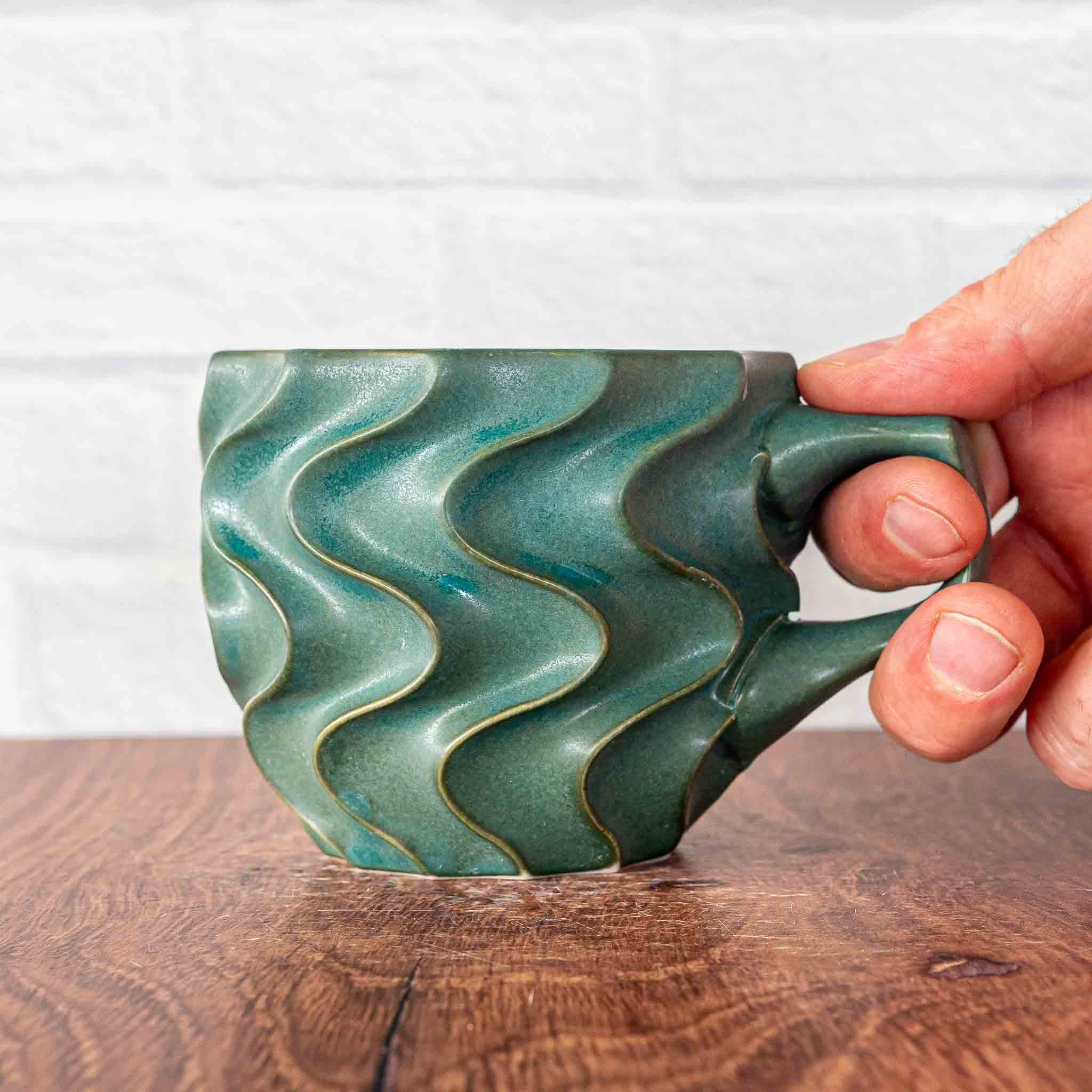 Hammerly Ceramics handmade slip-cast mug in smooth, matte jade green, deep wavy textured porcelain with angular handle