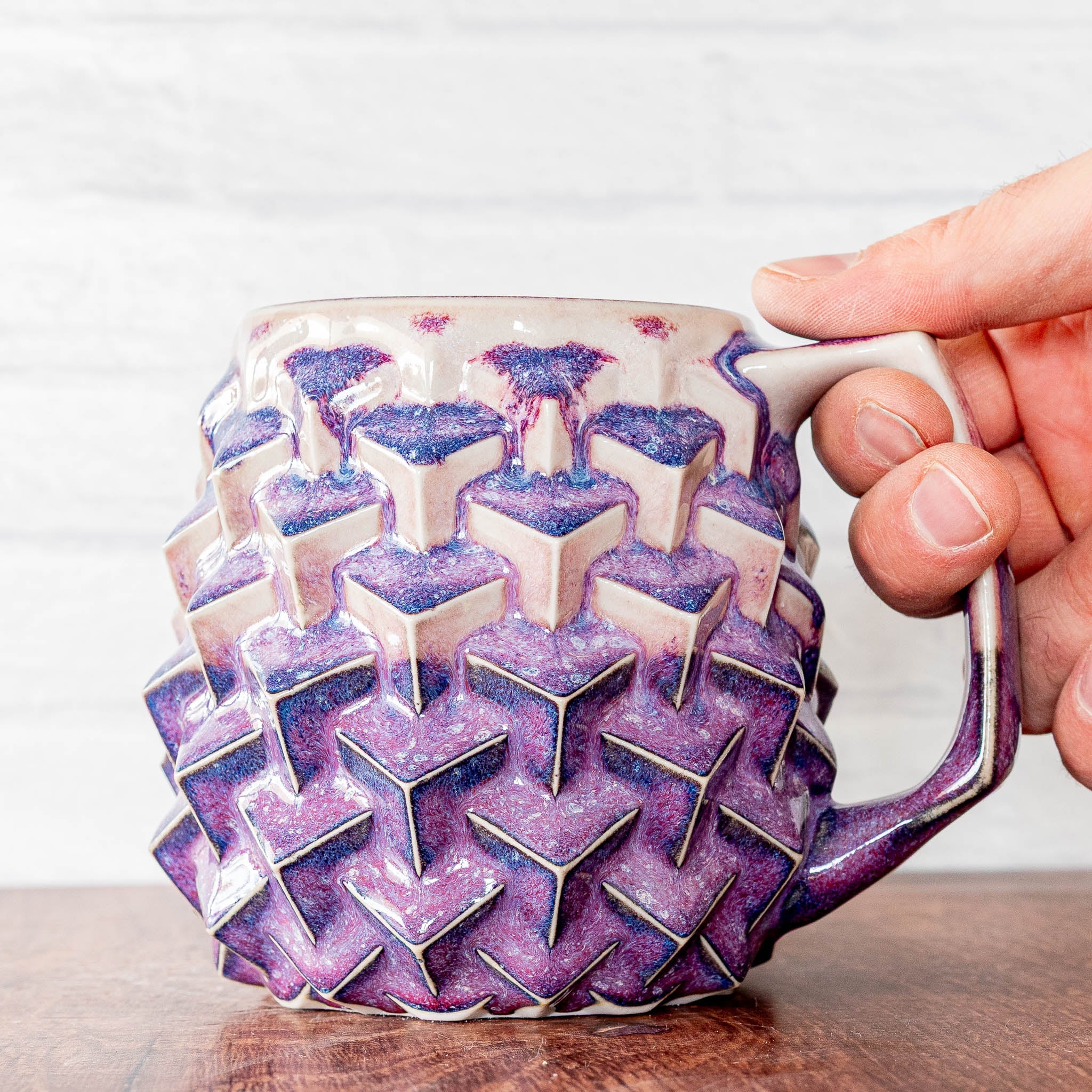 Hammerly Ceramics handmade slip-cast mug in white and deep navy glaze with purple drip transition, geometric cubes textured porcelain