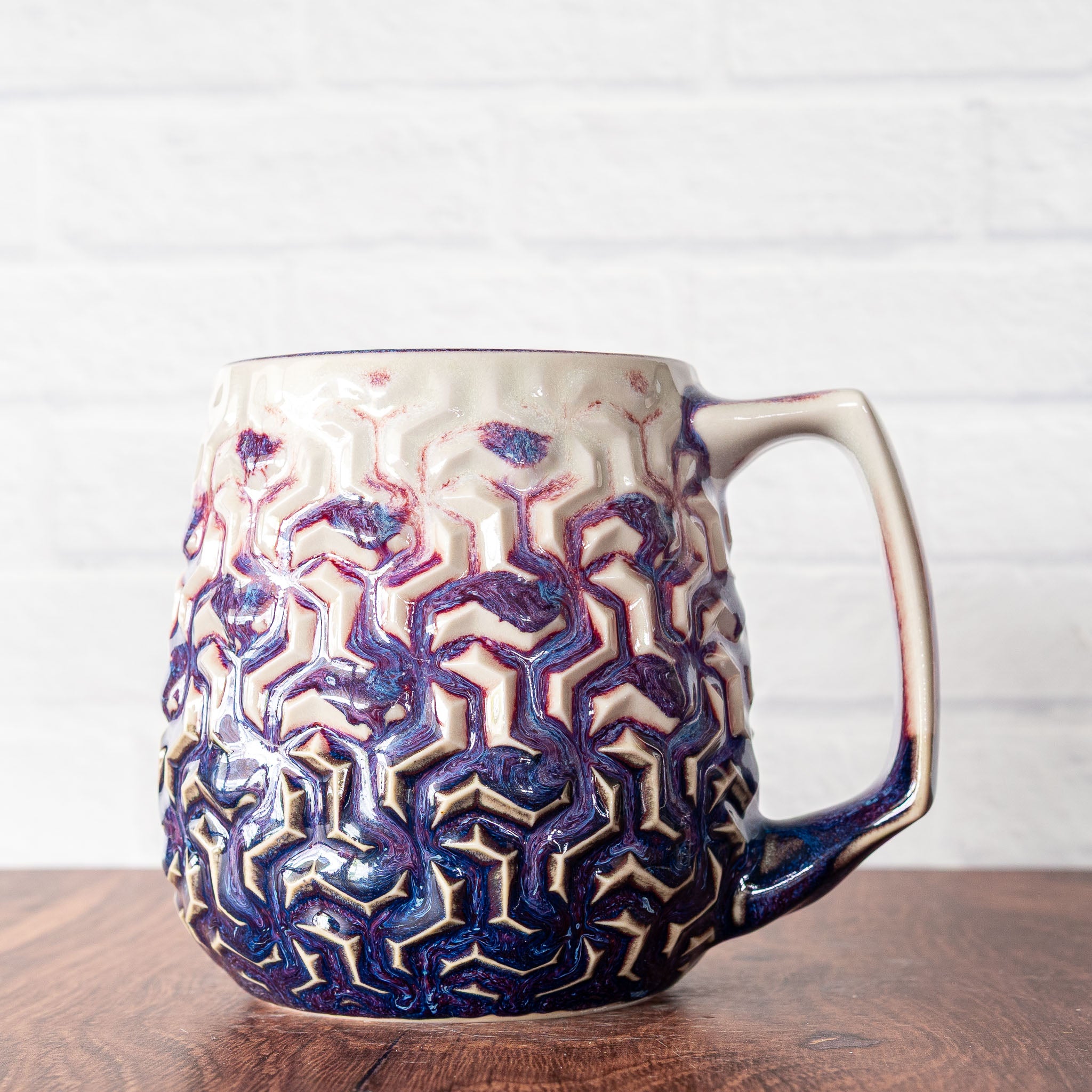 Hammerly Ceramics handmade slip-cast mug in white and deep navy glaze with purple drip transition, interlocking geometric weave textured porcelain