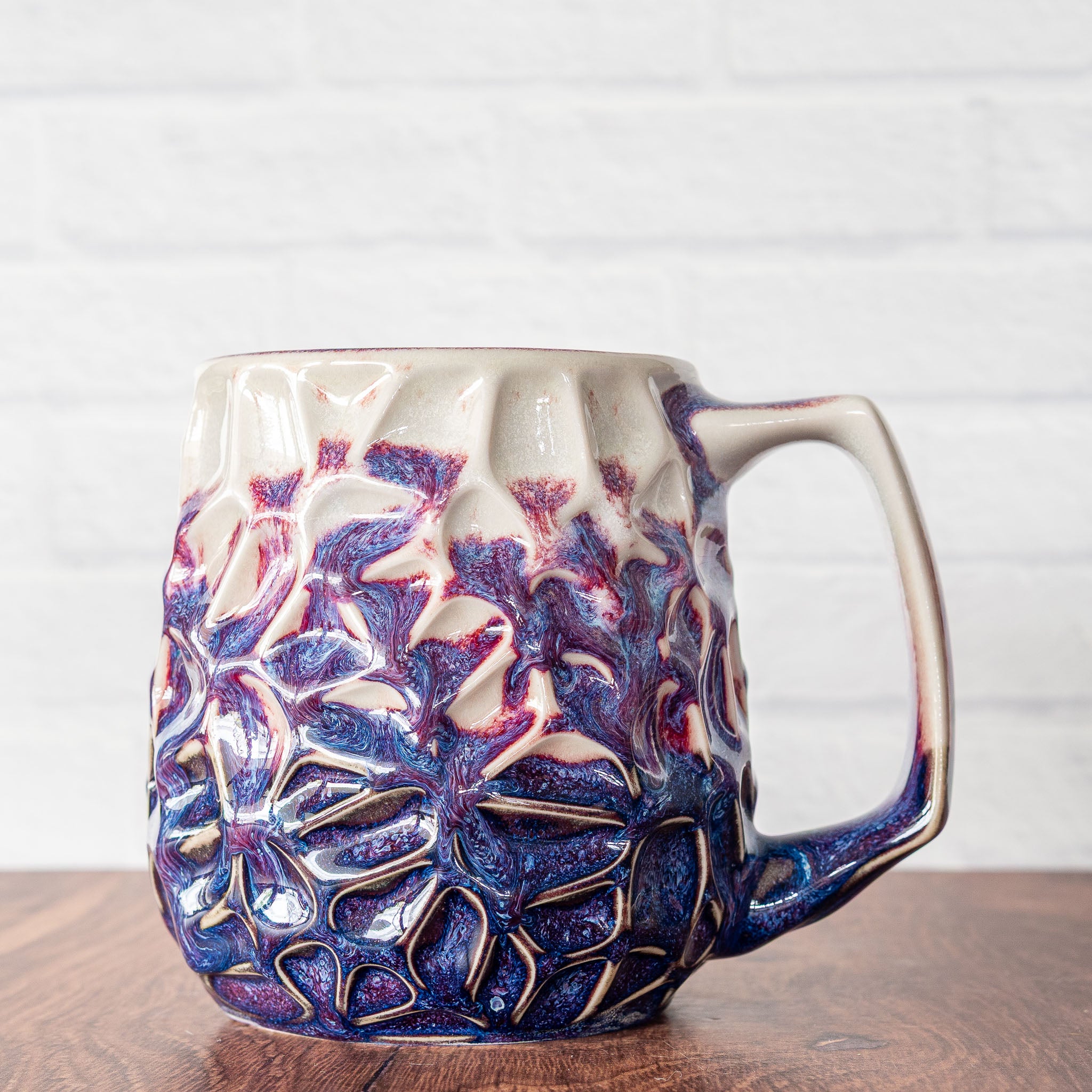 Hammerly Ceramics handmade slip-cast mug in white and deep navy glaze with purple drip transition, geometric organic cell-like textured porcelain