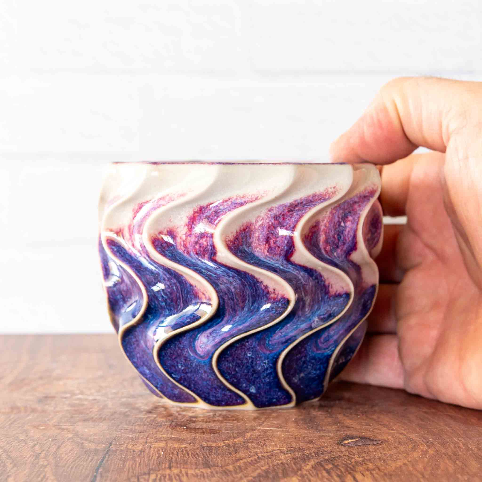 Hammerly Ceramics handmade slip-cast cup in white and deep navy glaze with purple drip transition, deep wavy textured porcelain 