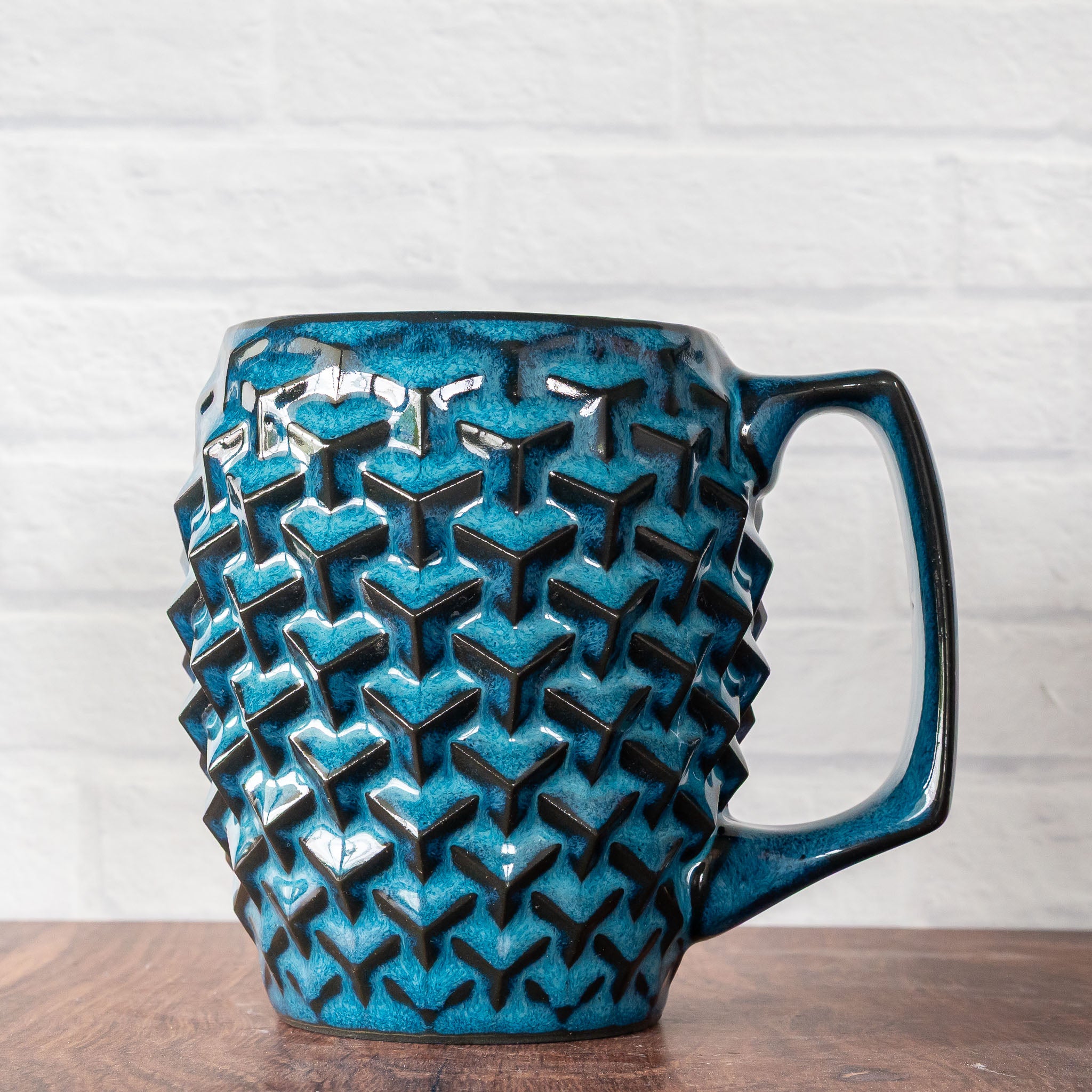 Hammerly Ceramics handmade slip-cast mug in ocean blue glaze with dark charcoal edges, geometric cubes textured porcelain