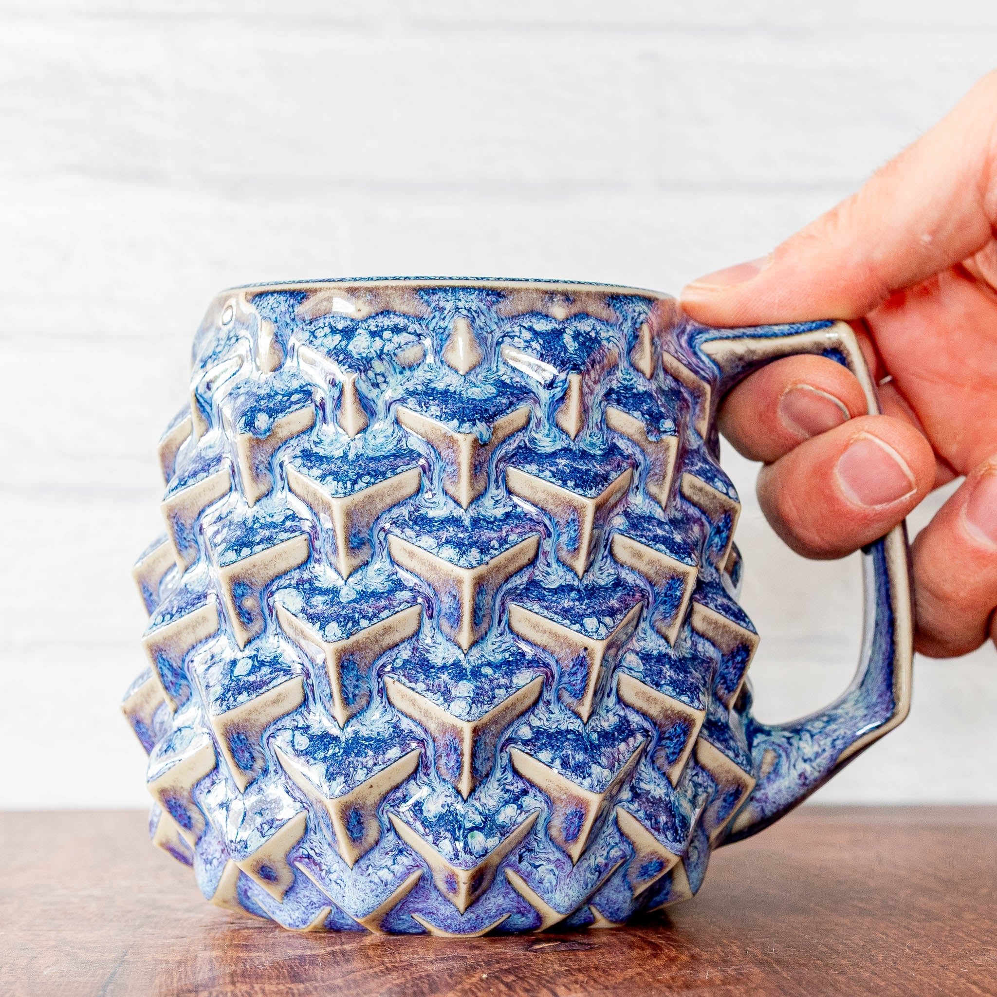 Hammerly Ceramics handmade slip-cast mug in swirls of various shades of blue, geometric cubes textured porcelain