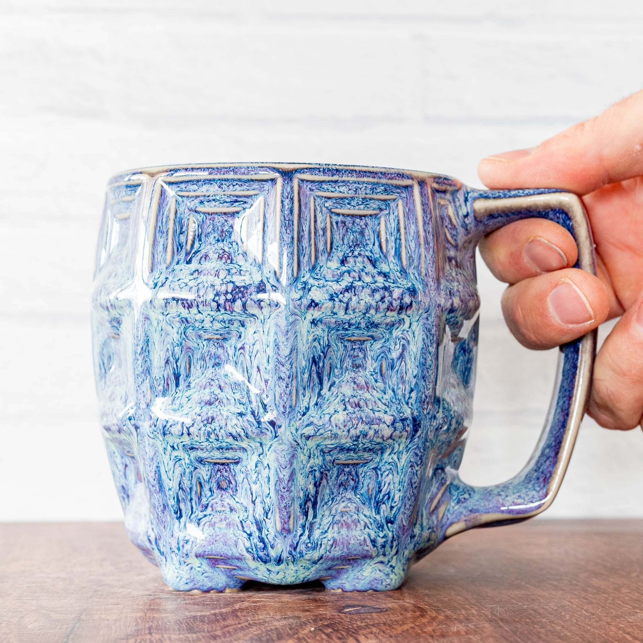 Hammerly Ceramics handmade slip-cast mug in swirls of various shades of blue, barrel-shaped with concentric recessed squares 